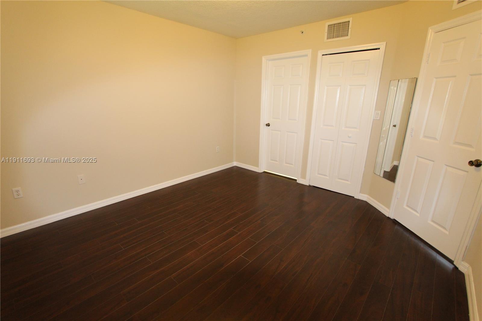 22801 Southwest 88th Place, Unit 205 Cutler Bay, FL 33190 - Photo 17 of 36 an empty room with wooden floor
