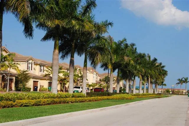 a view of a lake with a big yard and palm trees