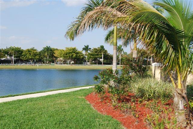 22801 Southwest 88th Place, Unit 205 Cutler Bay, FL 33190 - Photo 33 of 36 a view of a lake with a big yard and palm trees