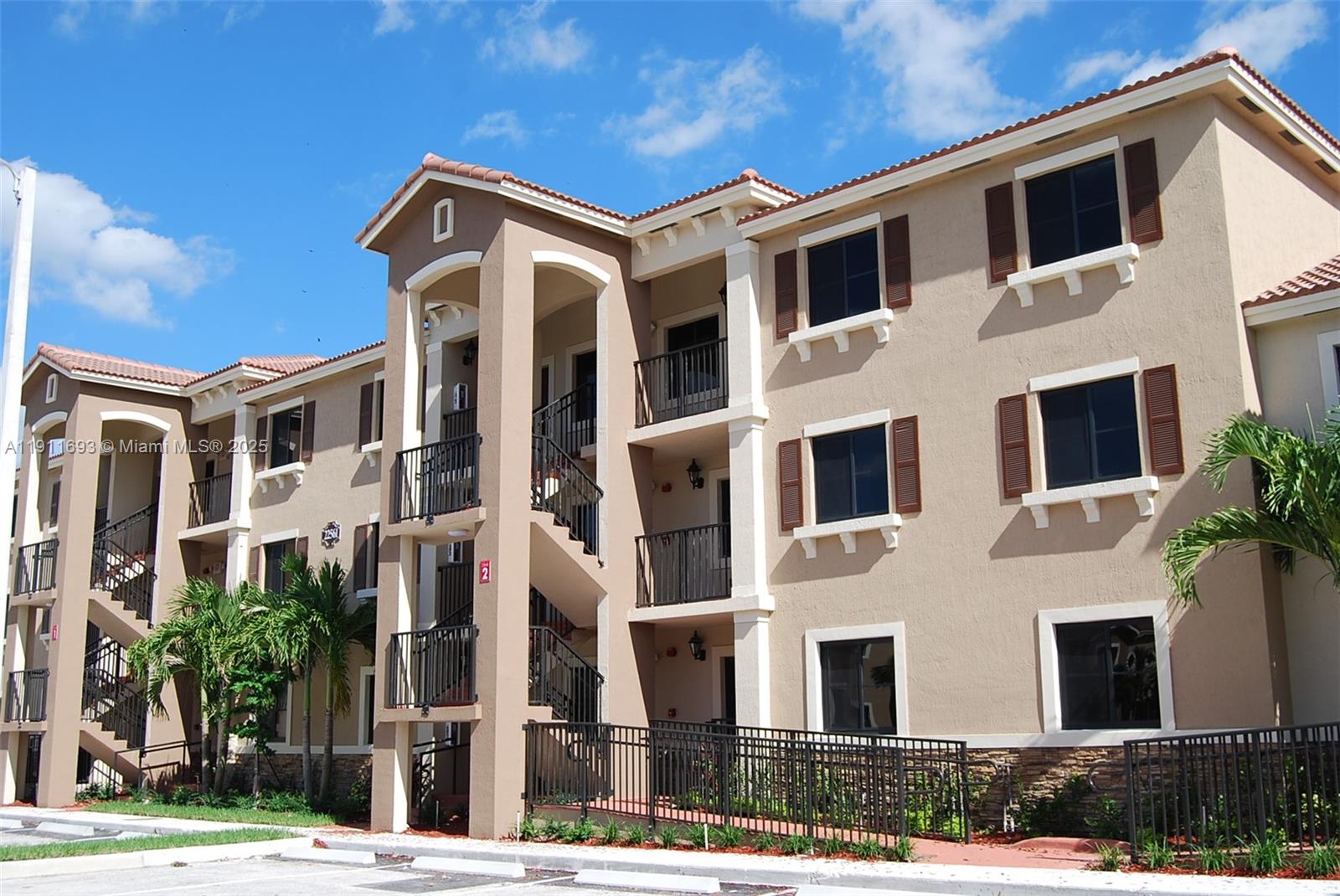 22801 Southwest 88th Place, Unit 205 Cutler Bay, FL 33190 - Photo 35 of 36 a front view of a building with a yard
