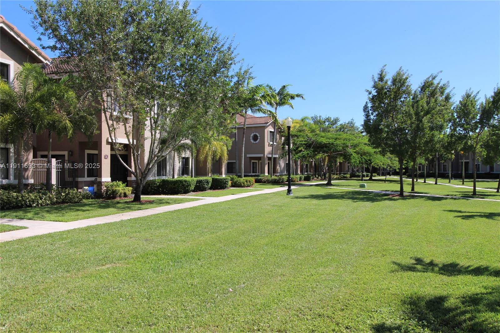 22801 Southwest 88th Place, Unit 205 Cutler Bay, FL 33190 - Photo 36 of 36 a view of a house with a big yard and large trees