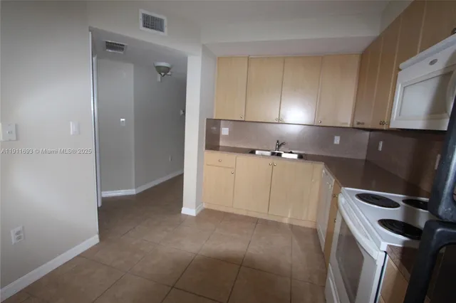 a kitchen with a refrigerator sink and cabinets