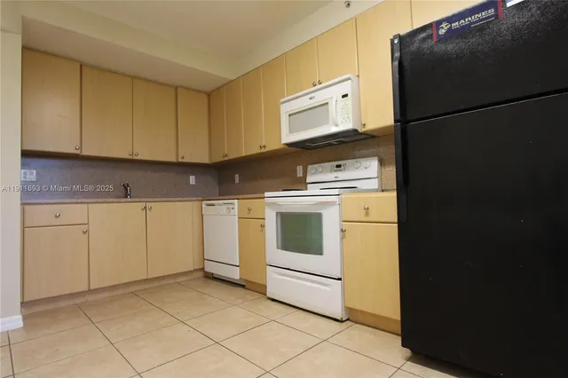 a kitchen with cabinets appliances and sink