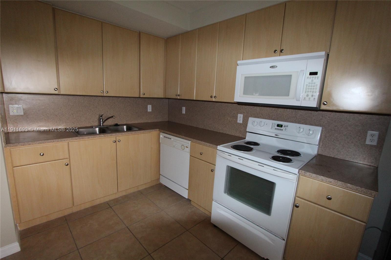 22801 Southwest 88th Place, Unit 205 Cutler Bay, FL 33190 - Photo 10 of 36 a kitchen with cabinets appliances and sink
