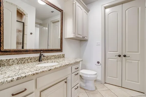 a bathroom with a granite countertop shower mirror and vanity