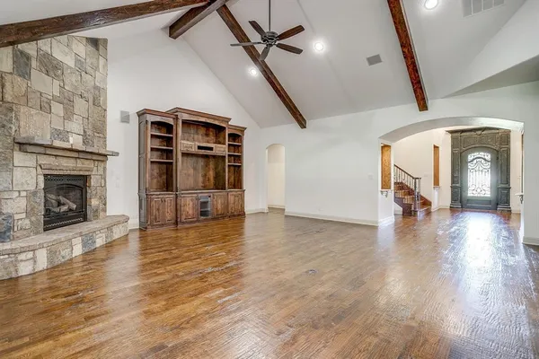 a view of a livingroom with wooden floor fireplace and a window
