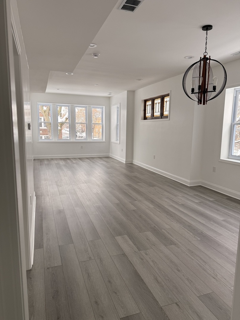 2101 Gunderson Avenue, Unit 2 Berwyn, IL 60402 - Photo 7 of 11 a view of an empty room with wooden floor and a window