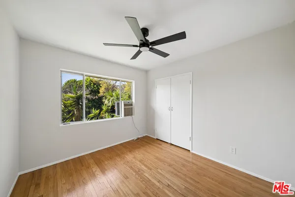 a view of a big room with wooden floor and windows