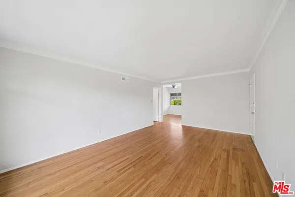 a view of an empty room with wooden floor