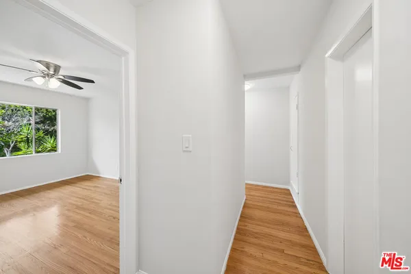 a view of a hallway with wooden floor and a chandelier