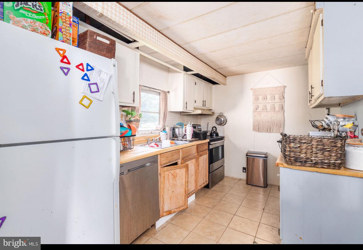 36372 Old Mill Road Ocean View, DE 19970 - Photo 10 of 14 a kitchen with stainless steel appliances a refrigerator sink and white cabinets