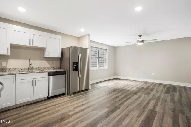 a kitchen with granite countertop a refrigerator and a sink