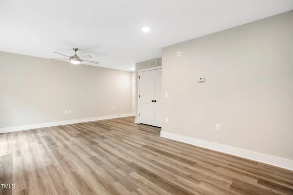a view of an empty room with wooden floor