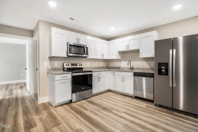a kitchen with granite countertop a refrigerator stove and microwave
