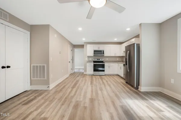 a view of kitchen with wooden floor electronic appliances and window