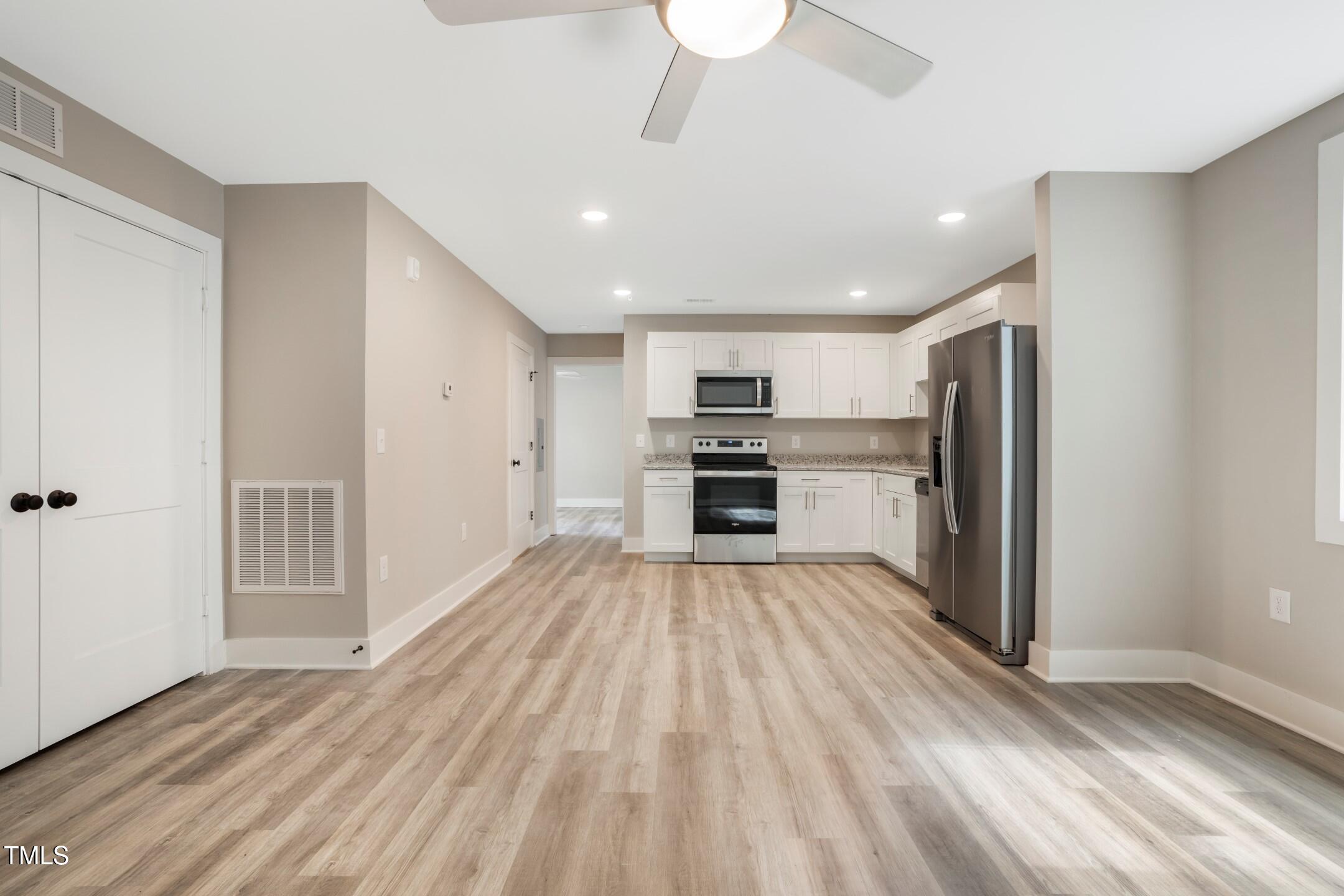 303 Linwood Street, Unit 306 Apex, NC 27502 - Photo 4 of 19 a view of kitchen with wooden floor electronic appliances and window