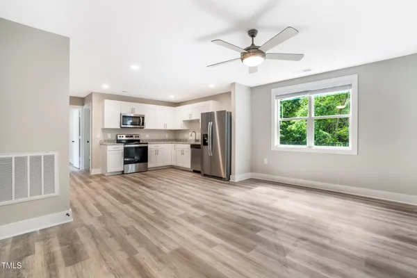 an empty room with windows and ceiling fan