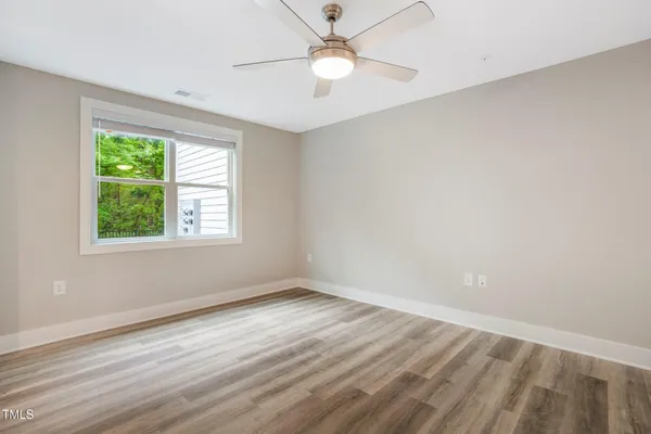 an empty room with a window and a fan