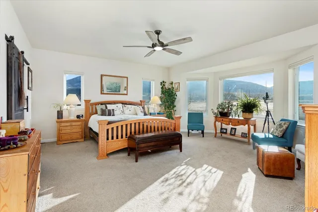 a spacious bedroom with a bed a couch and a window