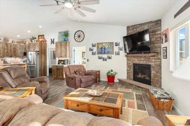 a living room with furniture a flat screen tv and a fireplace