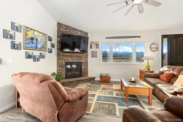 a living room with furniture a flat screen tv and a fireplace