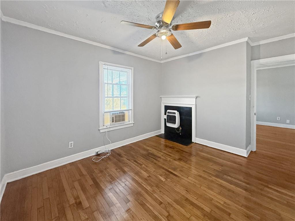 109 Vine Street Southwest, Unit A Atlanta, GA 30314 - Photo 5 of 14 a view of an empty room with wooden floor fireplace and a window