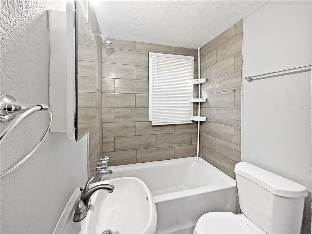 109 Vine Street Southwest, Unit A Atlanta, GA 30314 - Photo 8 of 14 a bathroom with a granite countertop bathtub sink vanity mirror and toilet