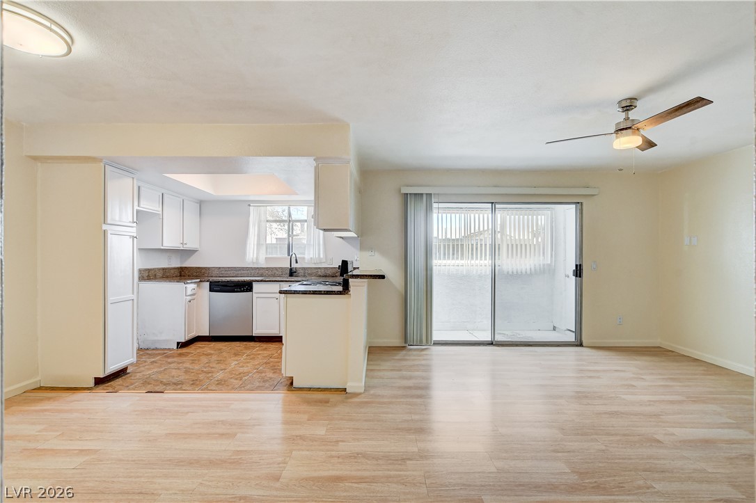 7200 West Pirates Cove Road, Unit 1050 Las Vegas, NV 89145 - Photo 24 of 24 Kitchen with light wood-style floors, white cabinets, ceiling fan, dishwasher, and open floor plan
