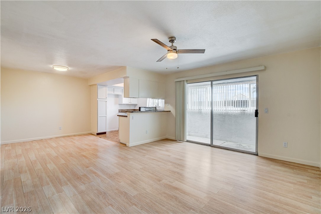 7200 West Pirates Cove Road, Unit 1050 Las Vegas, NV 89145 - Photo 10 of 24 Unfurnished living room with ceiling fan and light wood-style flooring