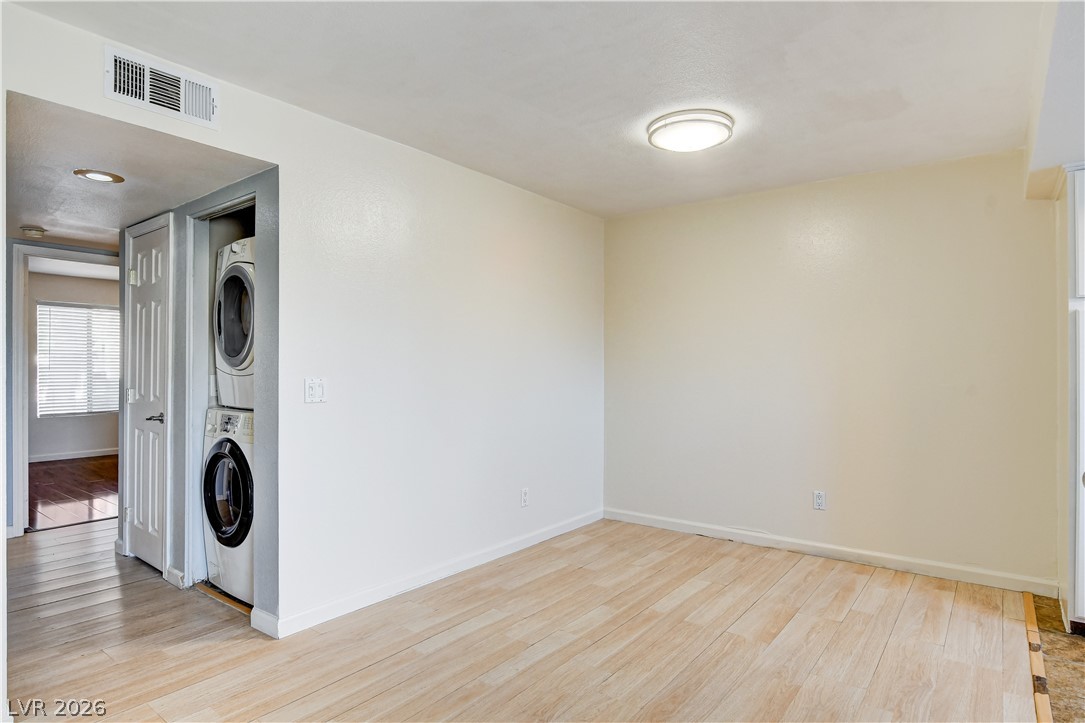 7200 West Pirates Cove Road, Unit 1050 Las Vegas, NV 89145 - Photo 11 of 24 Laundry area featuring light wood-style flooring and stacked washer and clothes dryer