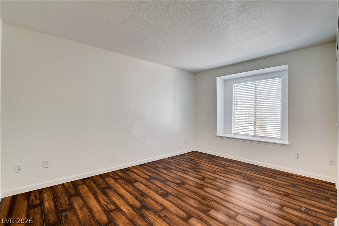 7200 West Pirates Cove Road, Unit 1050 Las Vegas, NV 89145 - Photo 16 of 24 Empty room with dark wood-style flooring and a textured ceiling
