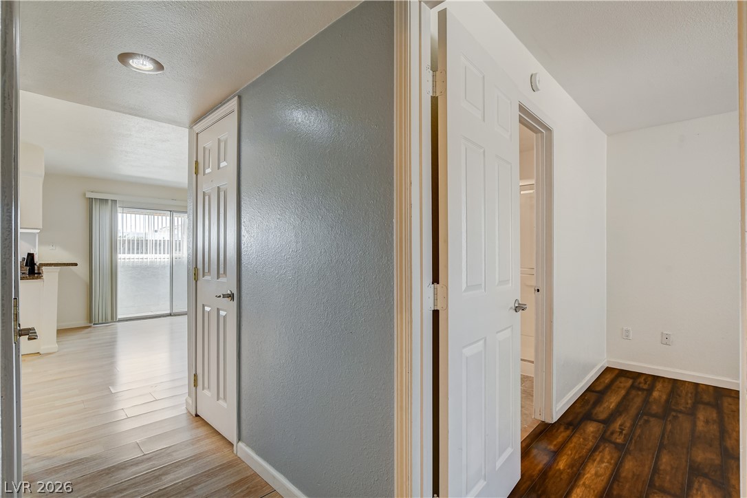 7200 West Pirates Cove Road, Unit 1050 Las Vegas, NV 89145 - Photo 17 of 24 Hall featuring dark wood finished floors, a textured wall, and a textured ceiling