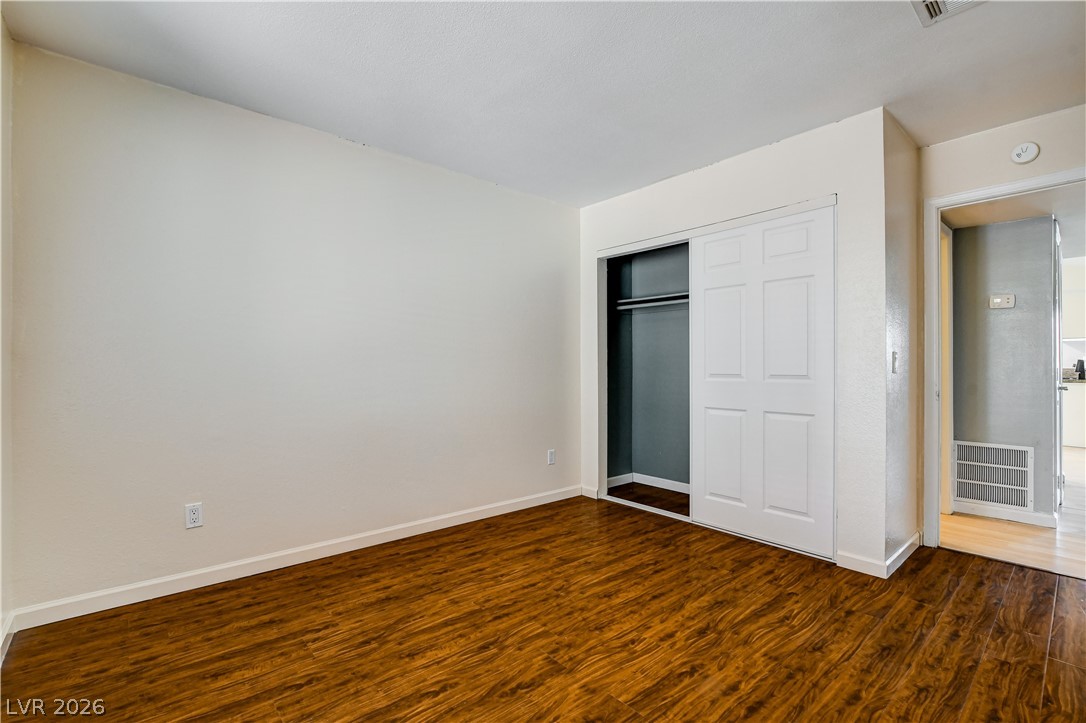 7200 West Pirates Cove Road, Unit 1050 Las Vegas, NV 89145 - Photo 19 of 24 Unfurnished bedroom with dark wood-style floors and a closet