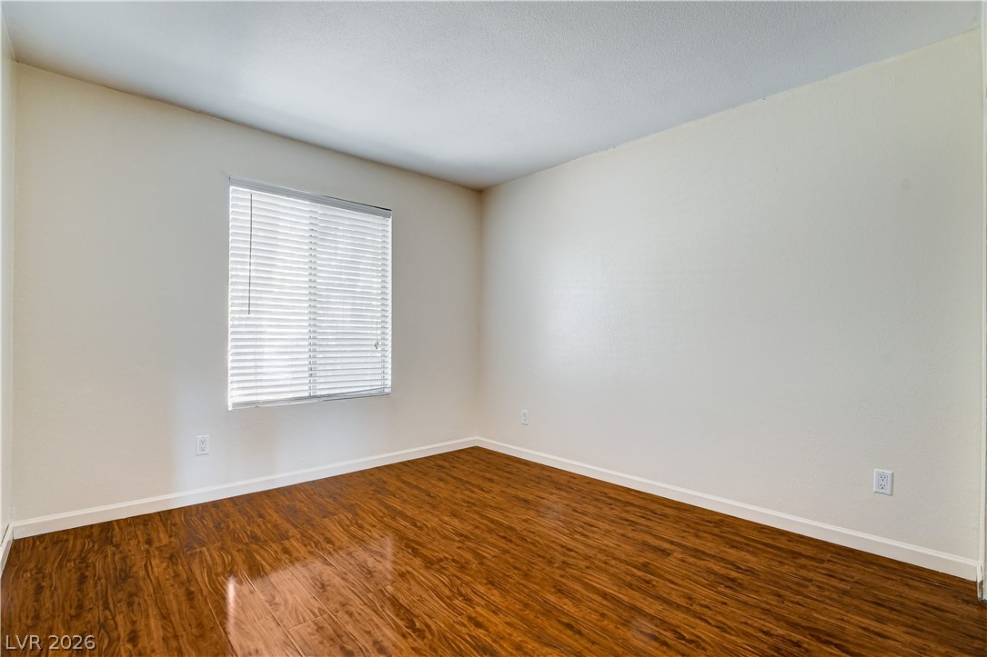 7200 West Pirates Cove Road, Unit 1050 Las Vegas, NV 89145 - Photo 20 of 24 Empty room with baseboards and dark wood-type flooring