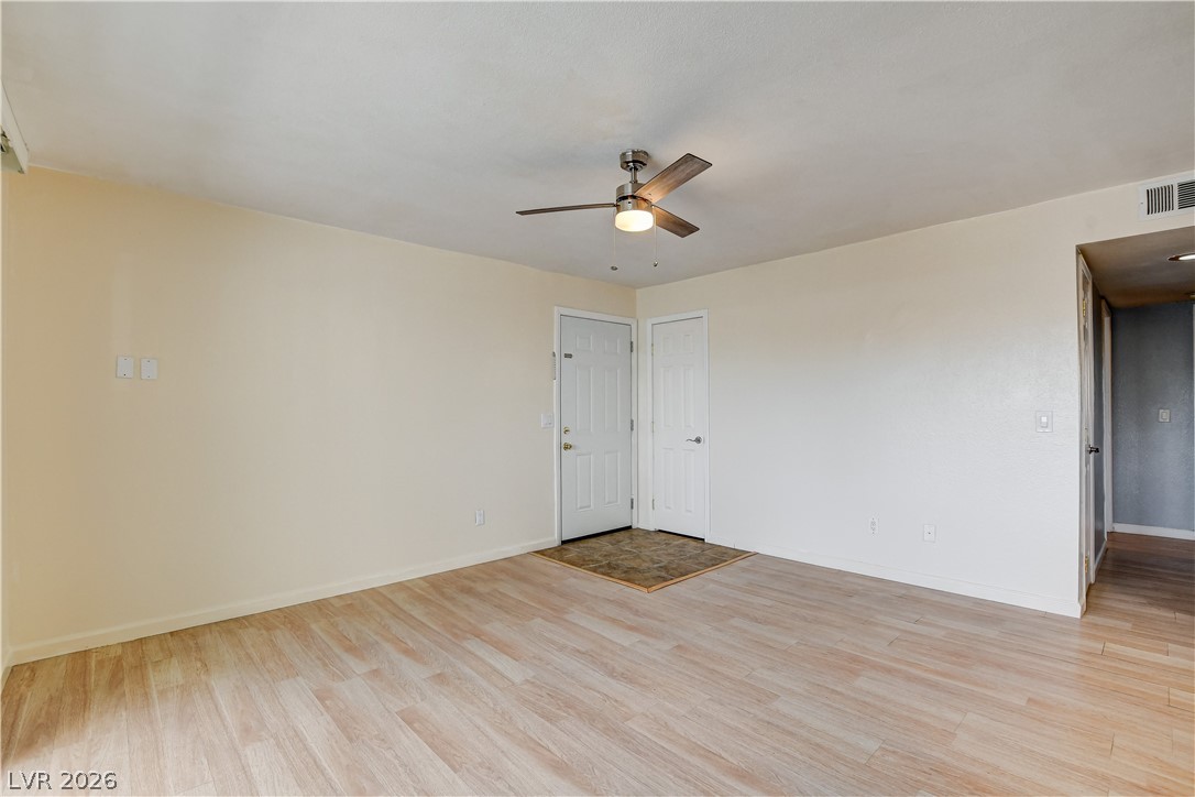 7200 West Pirates Cove Road, Unit 1050 Las Vegas, NV 89145 - Photo 3 of 24 Empty room with light wood-style flooring and ceiling fan