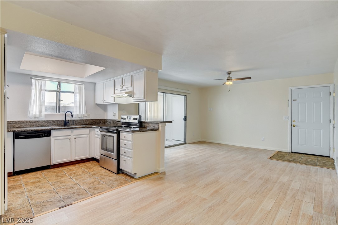 7200 West Pirates Cove Road, Unit 1050 Las Vegas, NV 89145 - Photo 23 of 24 Kitchen featuring stainless steel appliances, white cabinets, ceiling fan, light wood-type flooring, and open floor plan