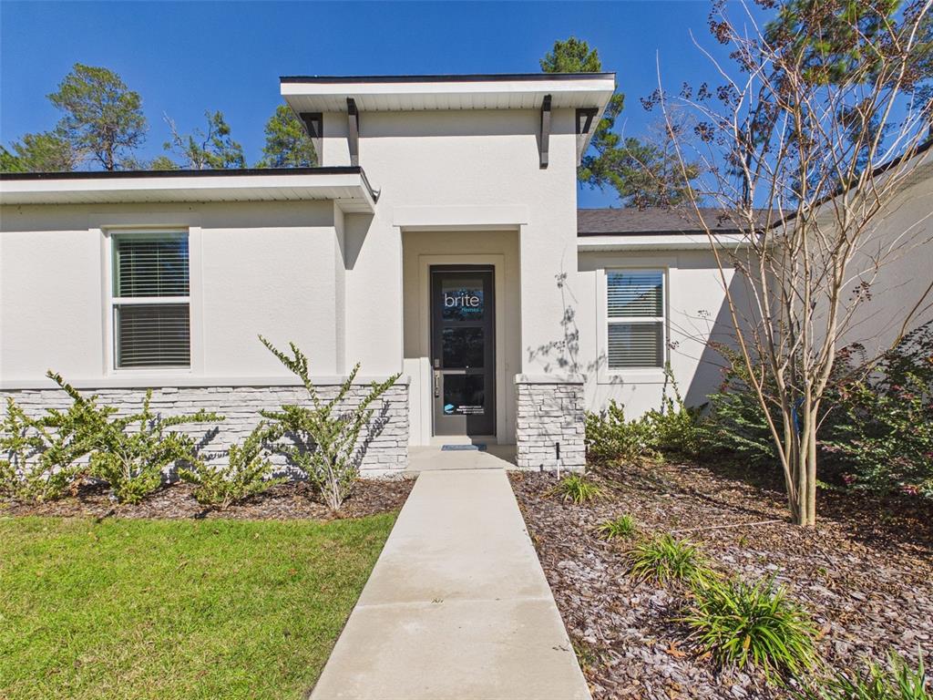 7110 Southwest 133rd Lane Ocala, FL 34473 - Photo 2 of 38 front view of a house with a yard