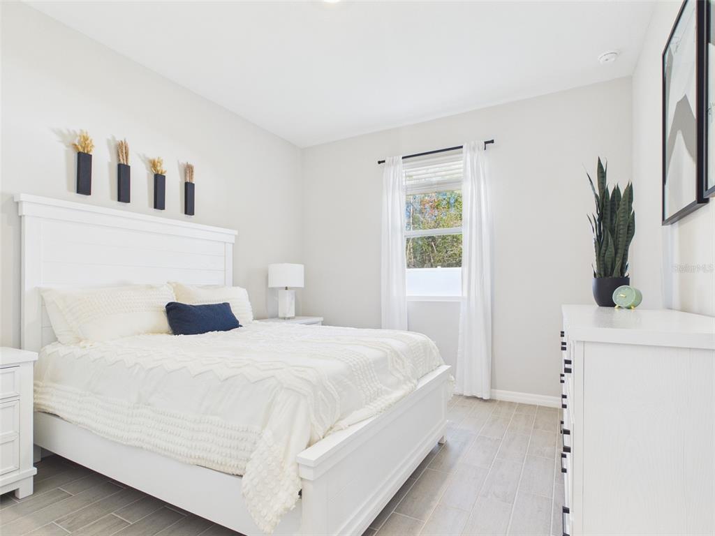 7110 Southwest 133rd Lane Ocala, FL 34473 - Photo 34 of 38 a bedroom with a large bed and a dresser