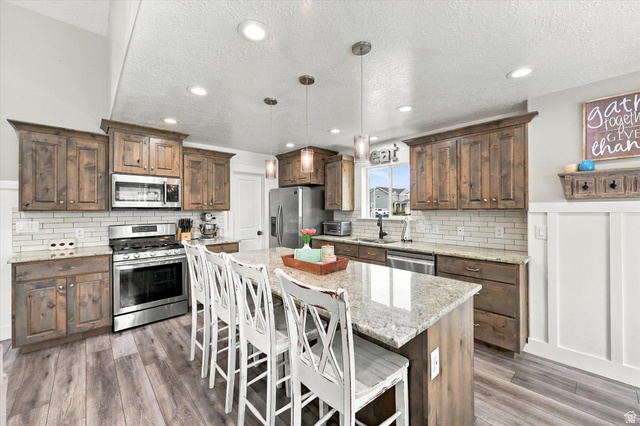 615 West 1870th Street South Payson, UT 84651 - Photo 2 of 31 Kitchen featuring wood-finish flooring, recessed lighting, and a center island with a stone countertop