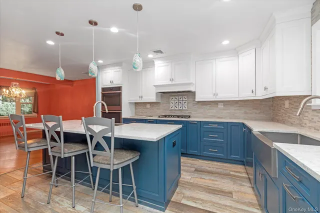 a kitchen with stainless steel appliances kitchen island granite countertop a table chairs sink and cabinets