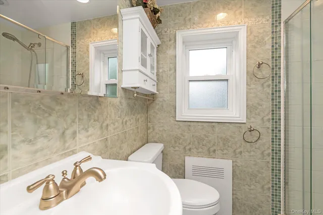 a bathroom with a toilet sink and mirror