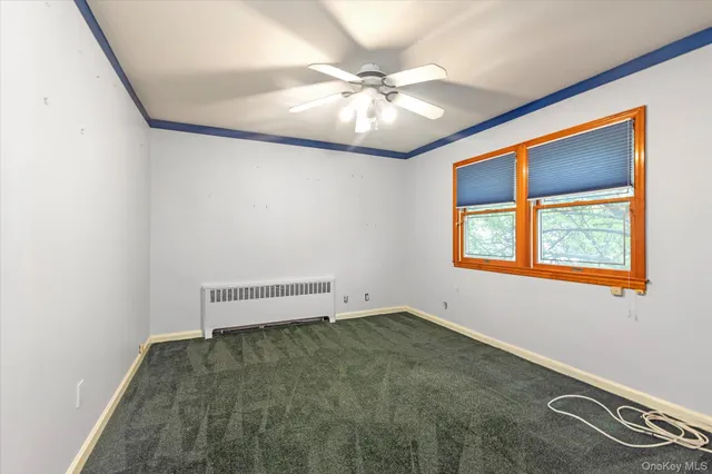 an empty room with a ceiling fan and a window