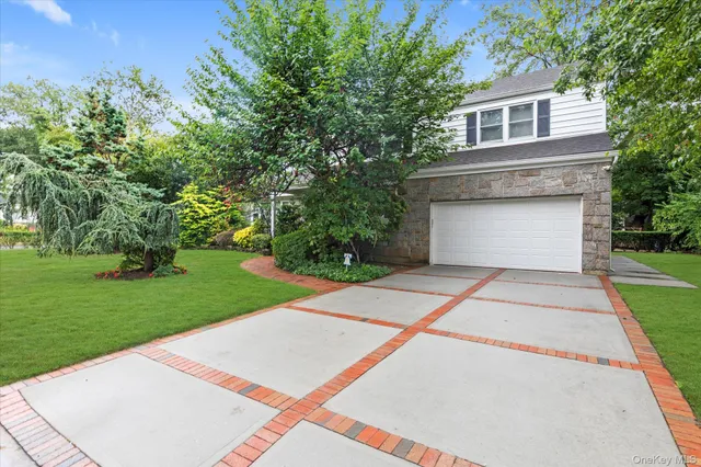 a front view of a house with a yard and trees