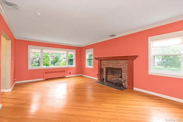 wooden floor fireplace and windows in an empty room
