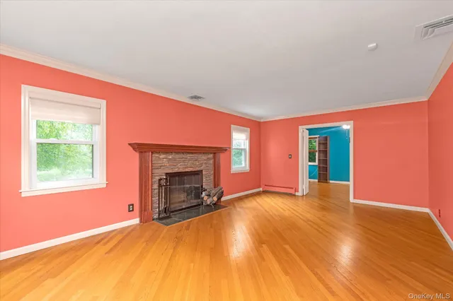 an empty room with a fireplace and windows