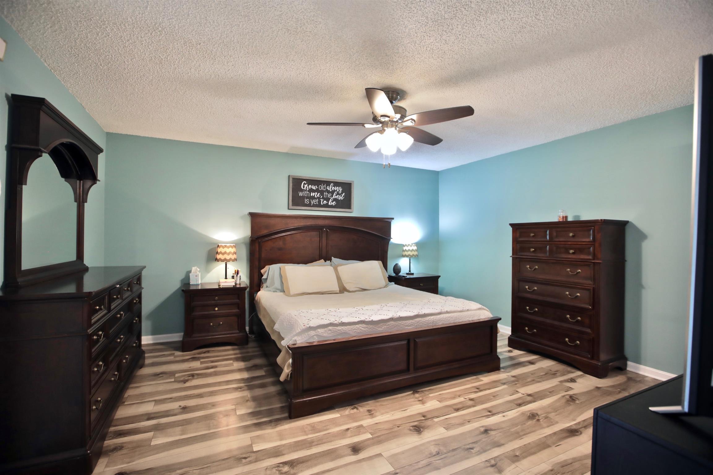 2674 New Hall Road Greenbrier, TN 37073 - Photo 16 of 30 a bedroom with a bed a dresser and a flat screen tv