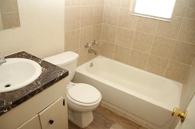 a bathroom with a granite countertop sink mirror vanity and toilet