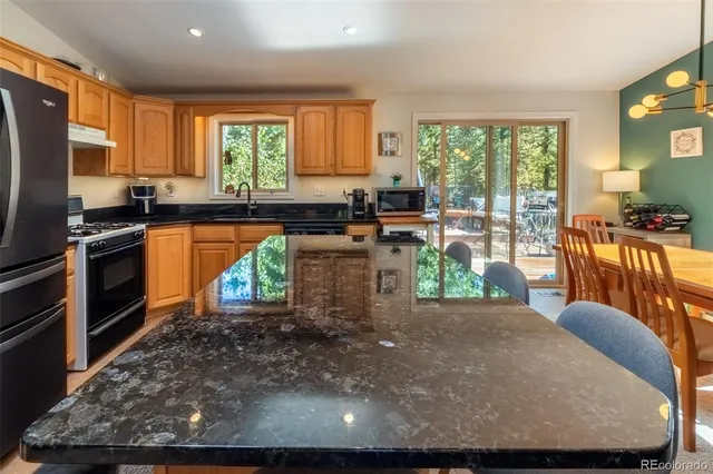 a view of a dining room with furniture a chandelier and large windows