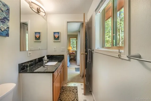 a bathroom with a granite countertop sink toilet and shower