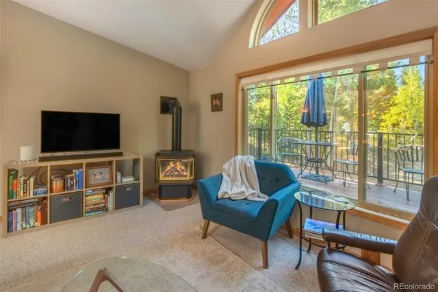 a living room with furniture a flat screen tv and a large window